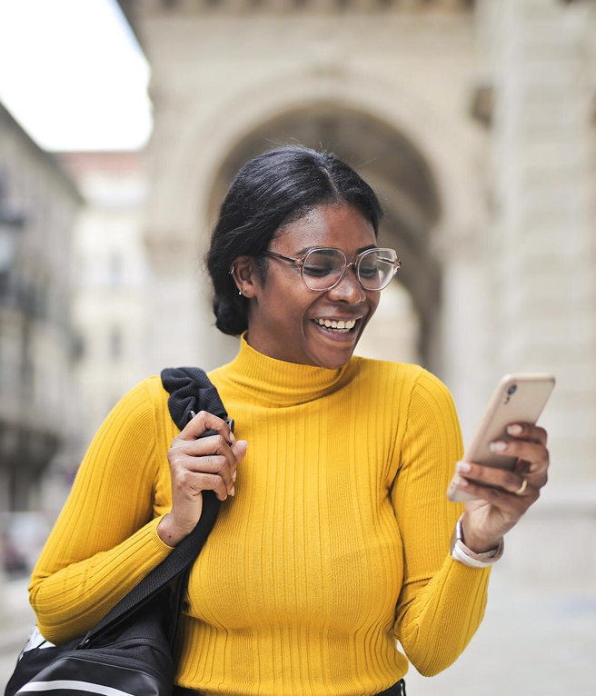 Woman in yellow sweater using phone